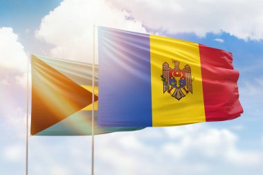 Sunny blue sky and flags of moldova and bahamas