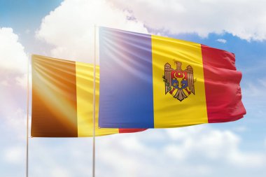 Sunny blue sky and flags of moldova and belgium