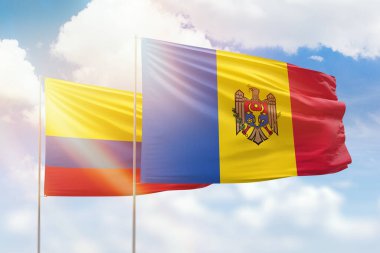 Sunny blue sky and flags of moldova and colombia
