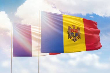 Sunny blue sky and flags of moldova and france