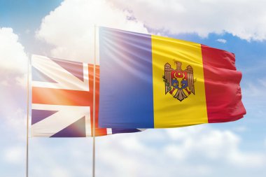 Sunny blue sky and flags of moldova and great britain