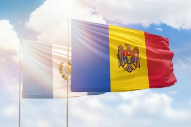 Sunny blue sky and flags of moldova and guatemala