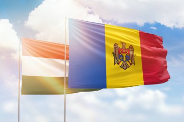Sunny blue sky and flags of moldova and hungary