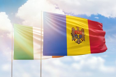 Sunny blue sky and flags of moldova and ireland