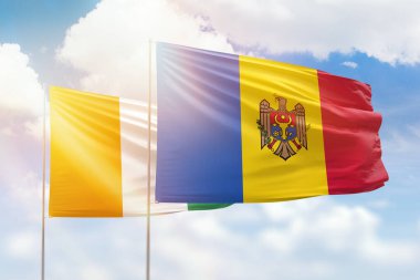 Sunny blue sky and flags of moldova and ivory coast