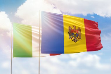 Sunny blue sky and flags of moldova and italy