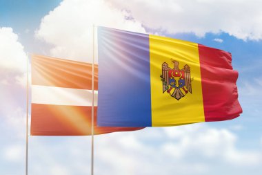 Sunny blue sky and flags of moldova and latvia