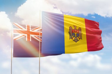 Sunny blue sky and flags of moldova and new zealand