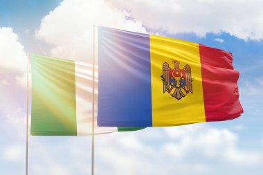 Sunny blue sky and flags of moldova and nigeria