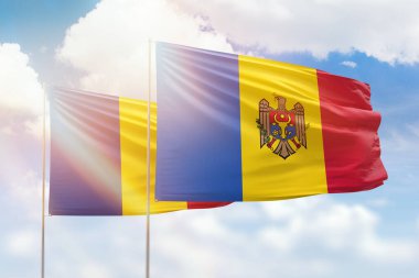 Sunny blue sky and flags of moldova and romania