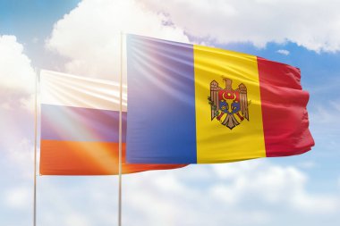 Sunny blue sky and flags of moldova and russia