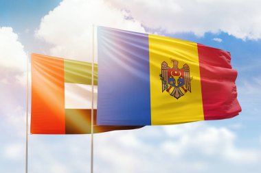 Sunny blue sky and flags of moldova and uae