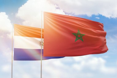 Sunny blue sky and flags of morocco and paraguay