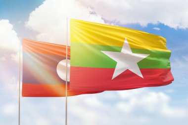 Sunny blue sky and flags of myanmar and laos
