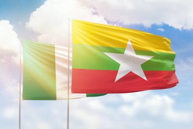 Sunny blue sky and flags of myanmar and nigeria