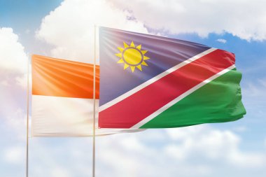 Sunny blue sky and flags of namibia and indonesia