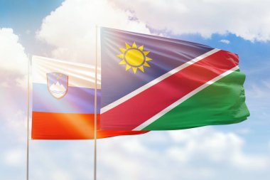 Sunny blue sky and flags of namibia and slovenia