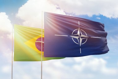 Sunny blue sky and flags of nato and brazil