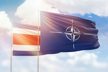 Sunny blue sky and flags of nato and costa rica