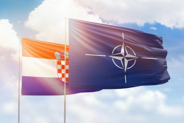 Sunny blue sky and flags of nato and croatia