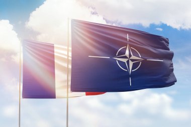 Sunny blue sky and flags of nato and france