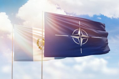 Sunny blue sky and flags of nato and guatemala