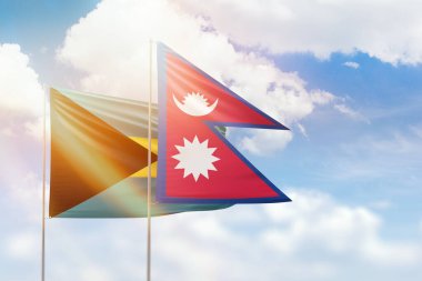 Sunny blue sky and flags of nepal and bahamas