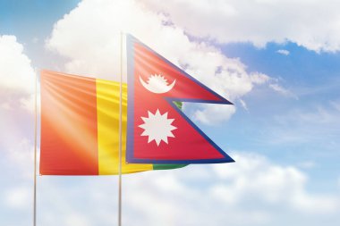 Sunny blue sky and flags of nepal and guinea