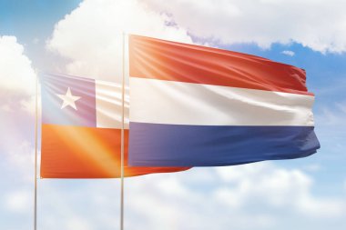 Sunny blue sky and flags of netherlands and chile