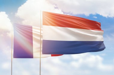 Sunny blue sky and flags of netherlands and france