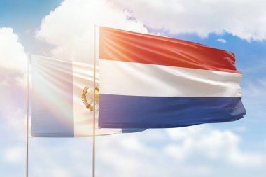 Sunny blue sky and flags of netherlands and guatemala