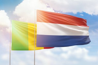 Sunny blue sky and flags of netherlands and mali