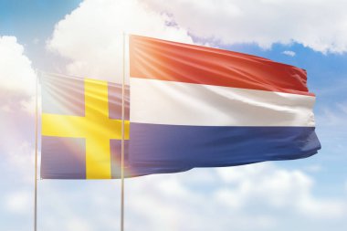 Sunny blue sky and flags of netherlands and sweden