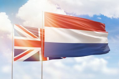 Sunny blue sky and flags of netherlands and united kingdom