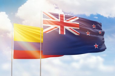 Sunny blue sky and flags of new zealand and colombia