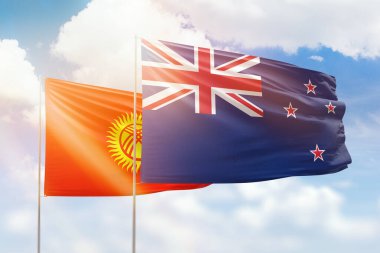 Sunny blue sky and flags of new zealand and kyrgyzstan