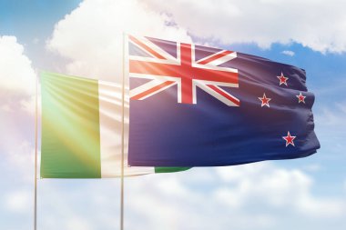 Sunny blue sky and flags of new zealand and nigeria