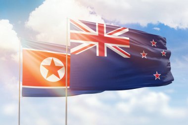 Sunny blue sky and flags of new zealand and north korea