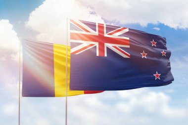 Sunny blue sky and flags of new zealand and romania
