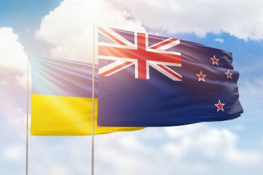Sunny blue sky and flags of new zealand and ukraine