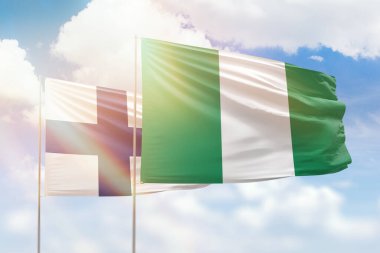 Sunny blue sky and flags of nigeria and finland