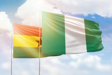Sunny blue sky and flags of nigeria and ghana