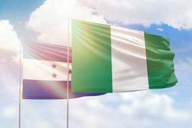 Sunny blue sky and flags of nigeria and honduras
