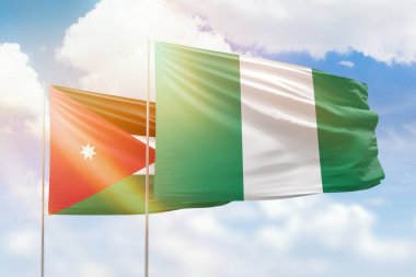 Sunny blue sky and flags of nigeria and jordan