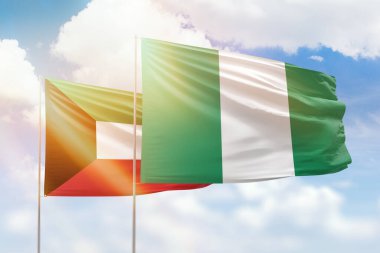 Sunny blue sky and flags of nigeria and kuwait