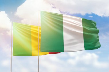 Sunny blue sky and flags of nigeria and mali