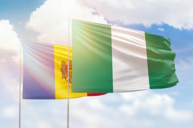 Sunny blue sky and flags of nigeria and moldova