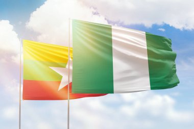 Sunny blue sky and flags of nigeria and myanmar