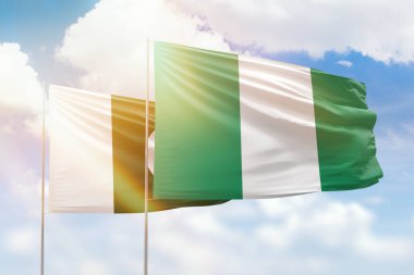 Sunny blue sky and flags of nigeria and pakistan