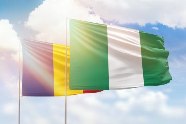Sunny blue sky and flags of nigeria and romania